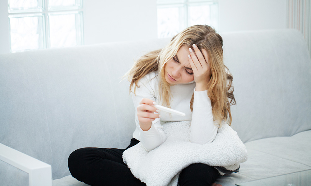 Pregnancy test. Worried sad woman Looking at a Pregnancy Test after result