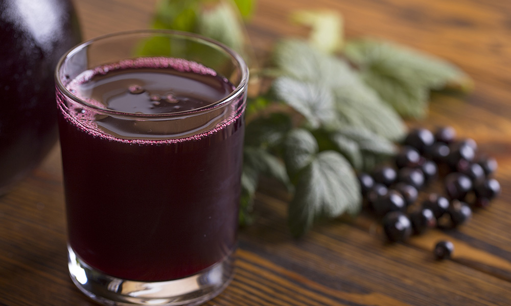 Blackcurrant drink  with some fruits on wooden background